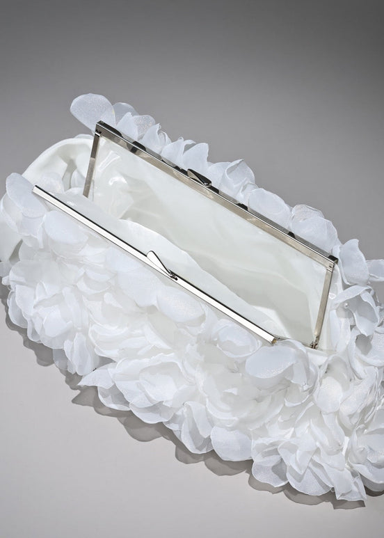 White clutch with ruffled on a gray background