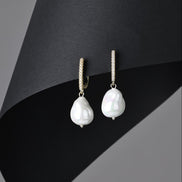 Pearl earrings on a black and gray background