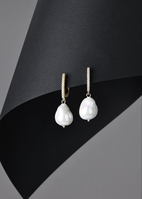 Pearl earrings on a black and gray background
