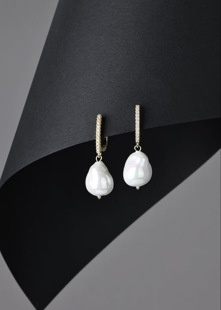 Pearl earrings on a black and gray background