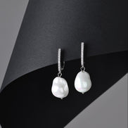 Pearl earrings on a black and gray background