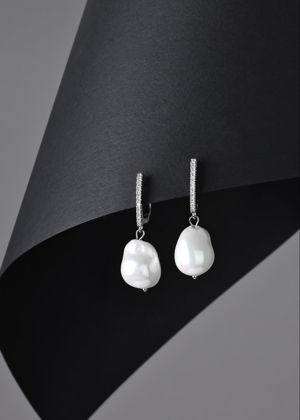 Pearl earrings on a black and gray background
