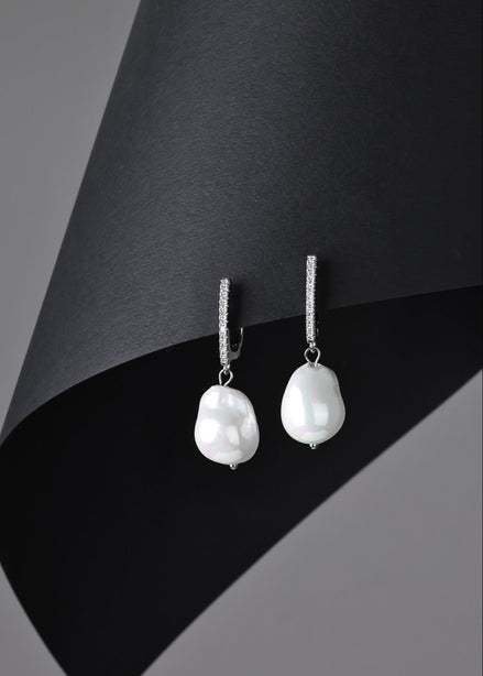 Pearl earrings on a black and gray background