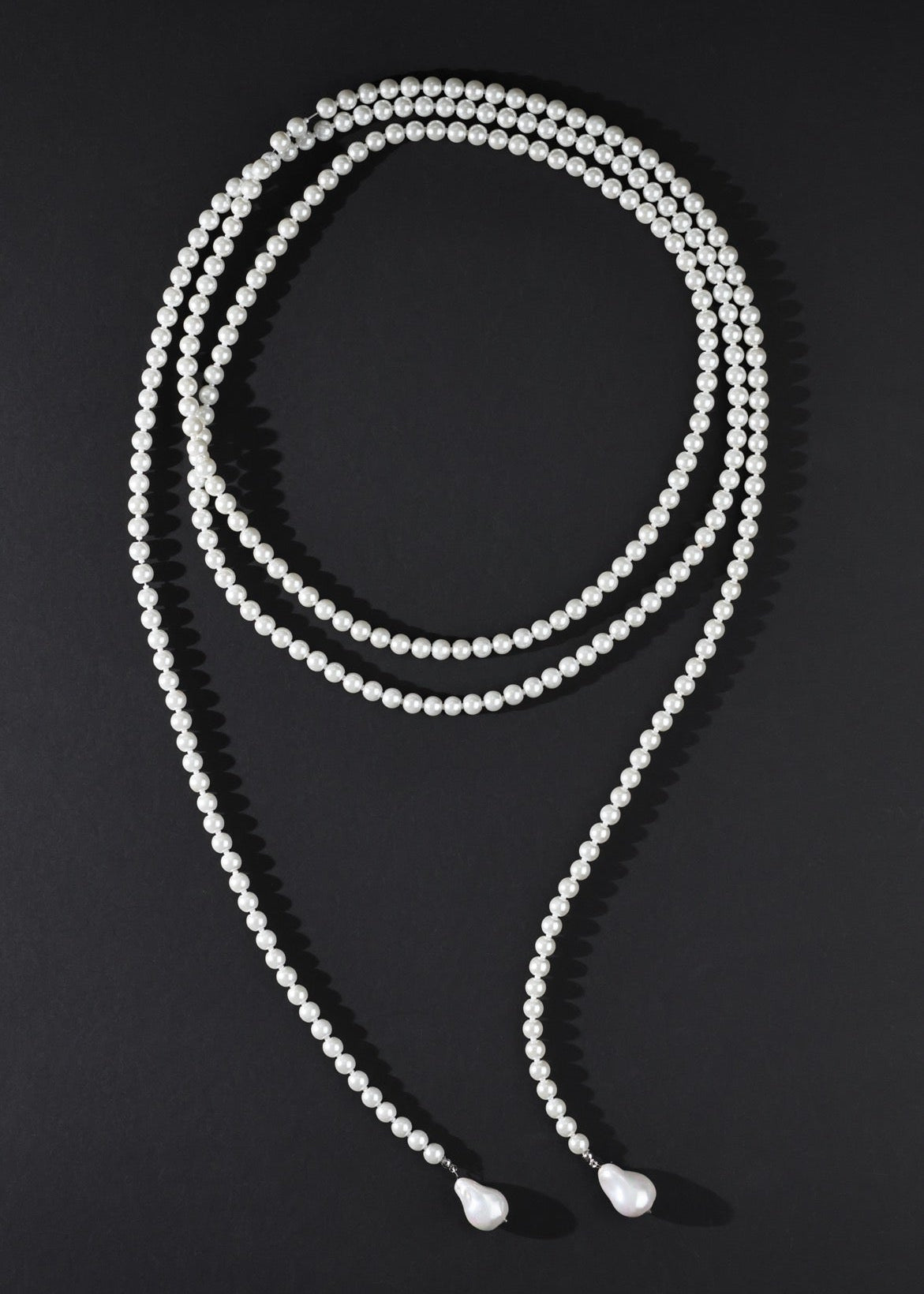 White beaded necklace on a black background