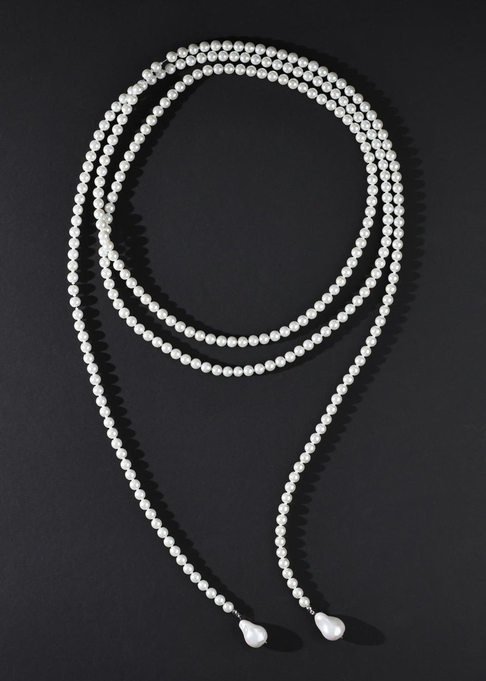 White beaded necklace on a black background