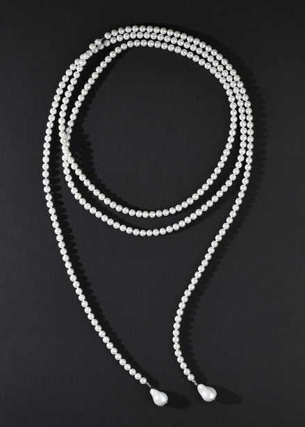 White beaded necklace on a black background