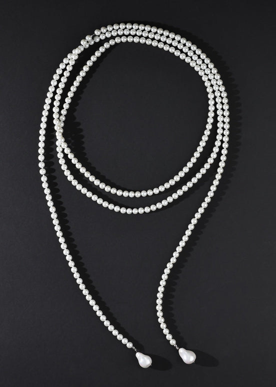 White beaded necklace on a black background