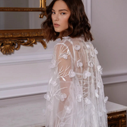 Woman wearing a white floral embroidered dress CELESTE by Linni Caro