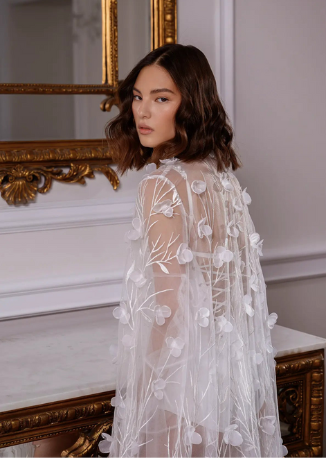 Woman wearing a white floral embroidered dress CELESTE by Linni Caro