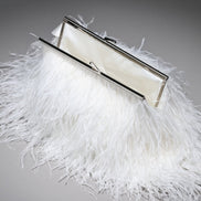 White feathered clutch bag with a silver frame on a gray background
