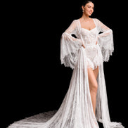 Woman wearing a white lace robe over a matching outfit on a black background