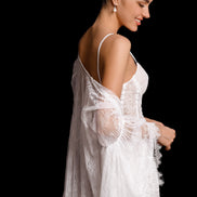 Woman wearing a white lace robe against a black background