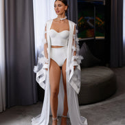 Woman in a white outfit with a flowing garment 