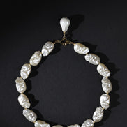 Pearl necklace with a pendant on a black background