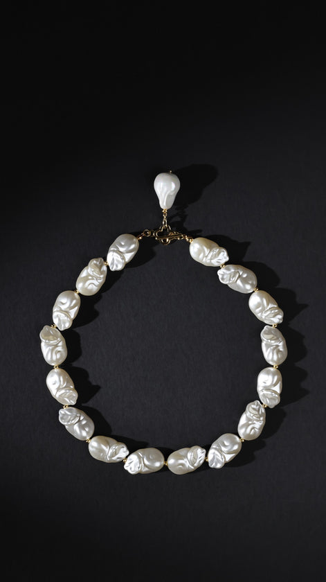 Pearl necklace with a pendant on a black background
