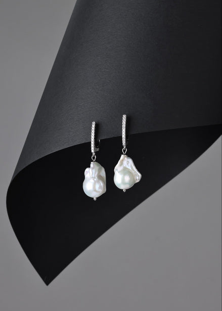 Pearl earrings on a black and gray background