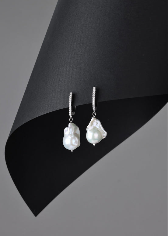 Pearl earrings on a black and gray background