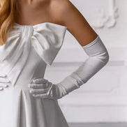 White off-shoulder dress with long gloves on a plain background