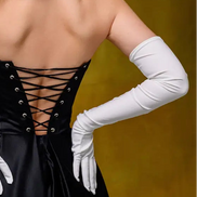 Black dress with lace-up back and white gloves on a yellow background