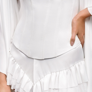 White strapless top and ruffled skirt on a plain background