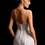 Woman wearing a white lace dress with thin straps on a black background