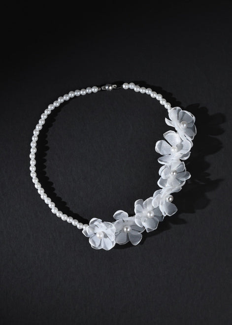 White floral headband on a black background
